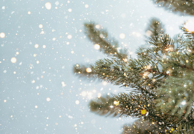 Nahaufnahme eines Weihnachtsbaums mit funkelnden Lichtern und Schneeflocken. Vintage-Farbton.