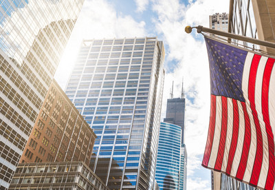 USA-Flagge mit den Wolkenkratzern Chicagos im Hintergrund.