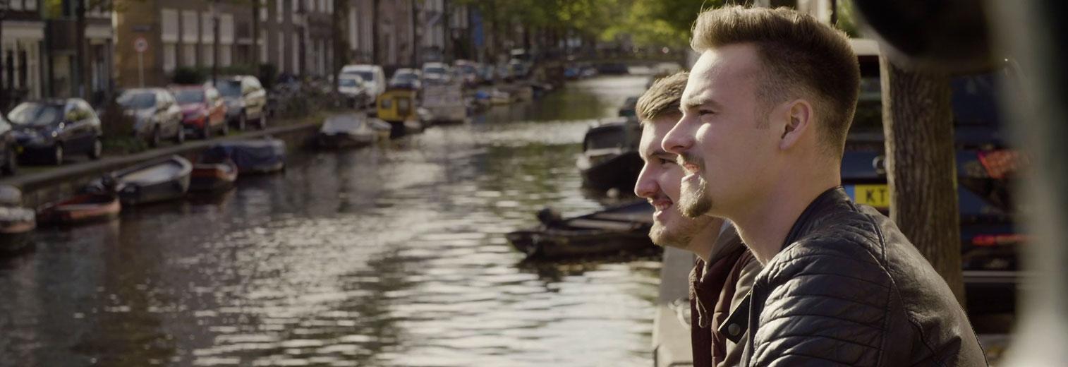 Leon und Leon sitzen während des Auslandspraktikums an einer Gracht in Amsterdam.