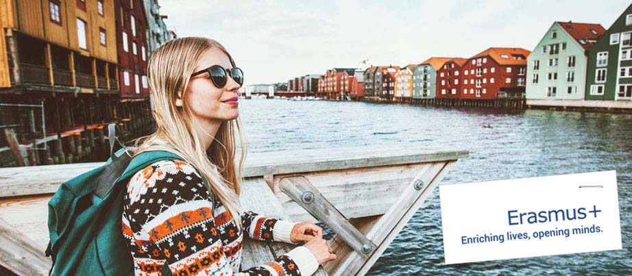 Eine junge Frau im Auslandspraktikum steht an einem Fluss in einer norwegischen Stadt.