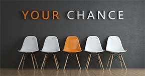 Foto: vier weiße und ein gelber Stuhl mittig stehen vor einer grauen Wand auf der der Schriftzug "your chance" zu sehen ist